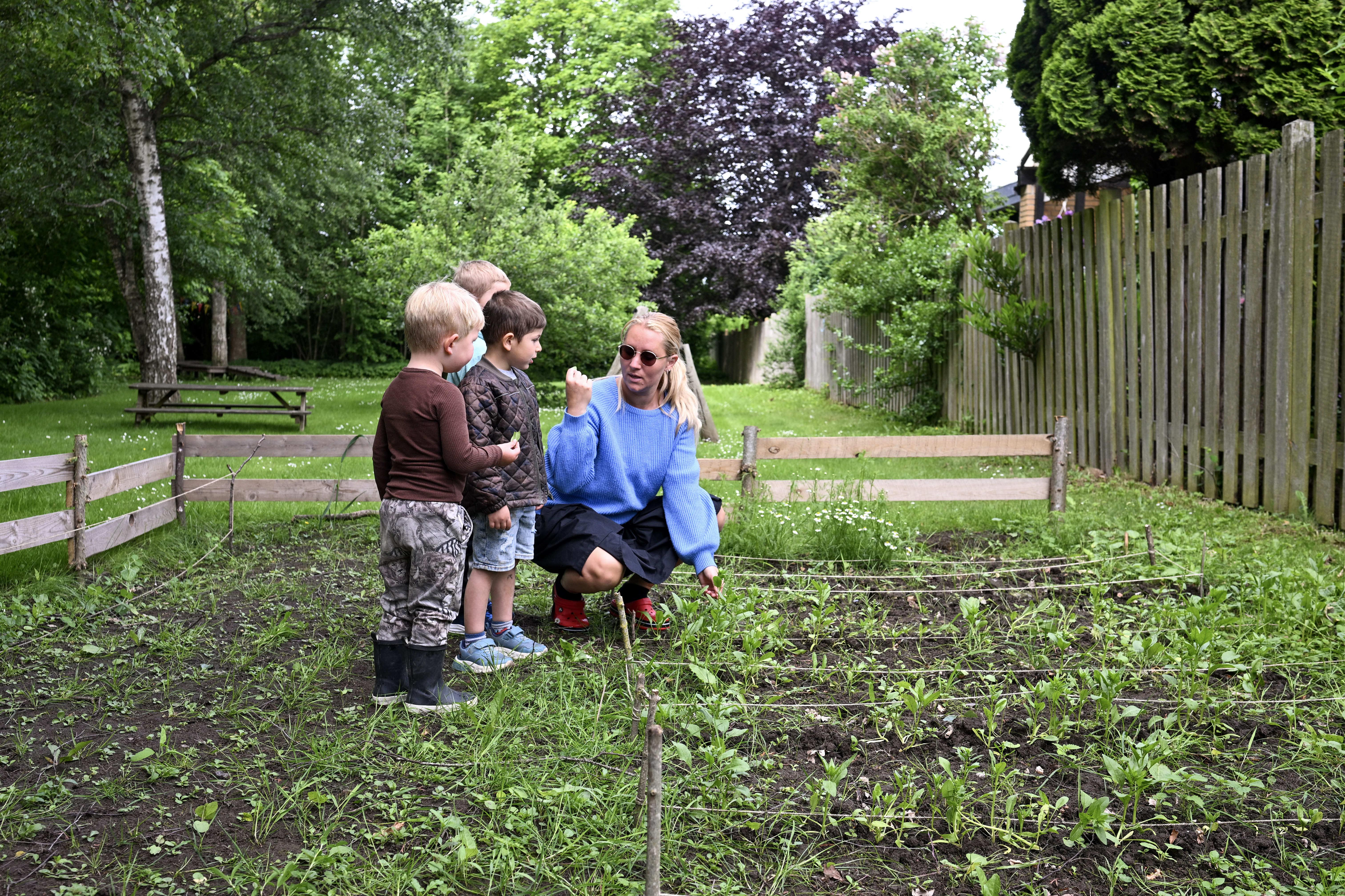 Voksen og børn kigger på planter