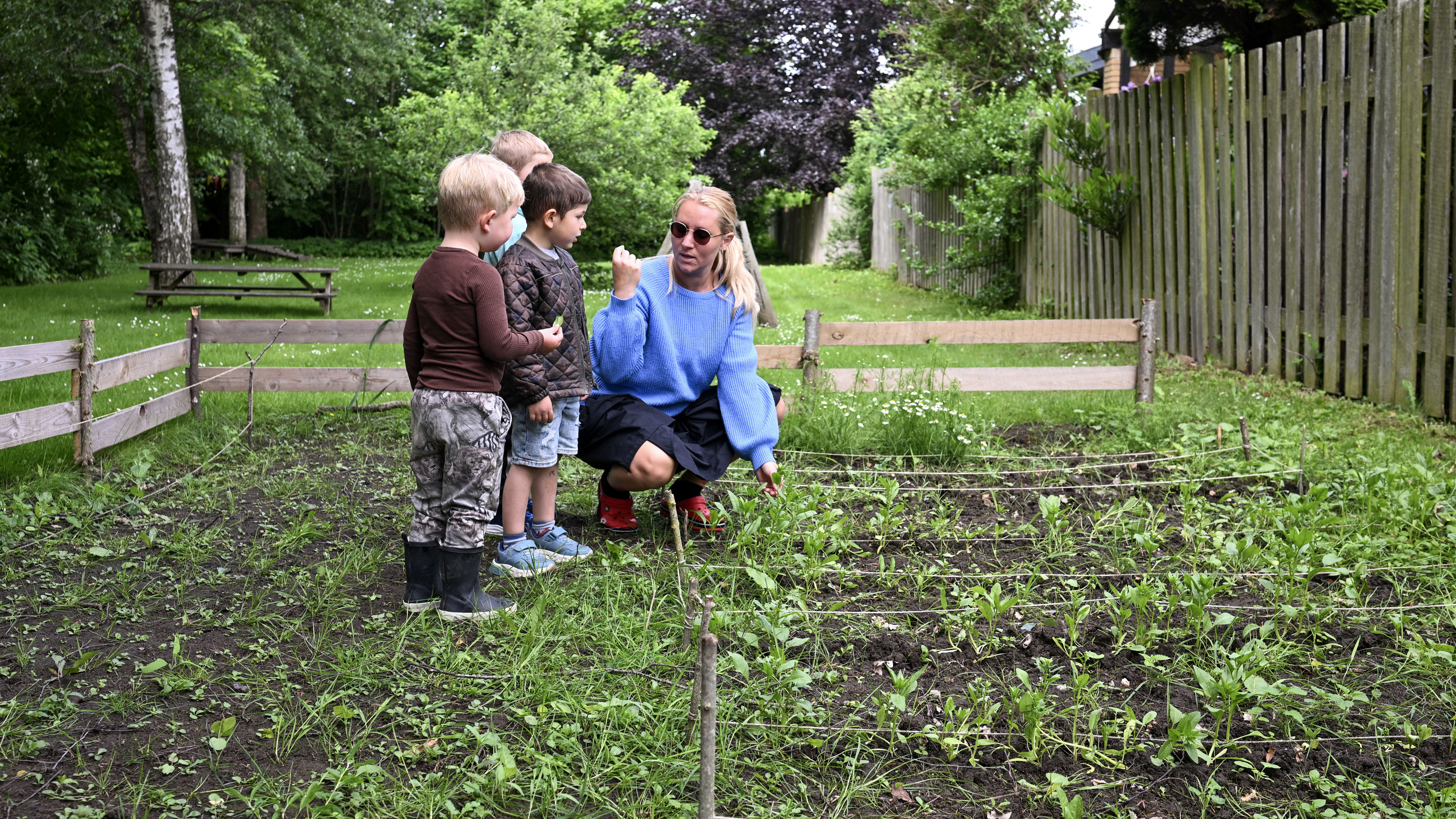 Voksen og børn kigger på planter
