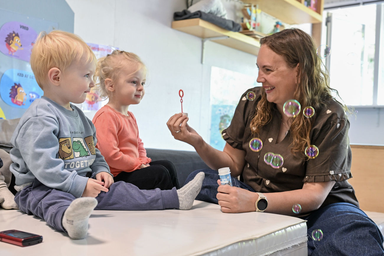 Børn og voksen blæser sæbebobler